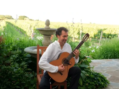 Tomas Rodriguez playing solo classical guitar in a garden at Wölffer Estate on Long Island.